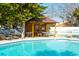 Community pool area with lounge chairs surrounding a covered outdoor table and seating at 4307 Gulf Dr # 202, Holmes Beach, FL 34217
