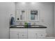 Bathroom featuring a double vanity with granite counters and framed mirrors at 4705 Hollingsworth Ave, Sarasota, FL 34233