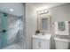 Bright bathroom featuring a tiled walk-in shower and white vanity with mirror at 4705 Hollingsworth Ave, Sarasota, FL 34233
