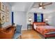 This bedroom boasts hardwood floors, vibrant floral bedding, a ceiling fan and a study area with a desk at 4705 Hollingsworth Ave, Sarasota, FL 34233