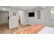 Comfortable bedroom features wood floors, a wall-mounted TV, and view into en-suite bathroom at 4705 Hollingsworth Ave, Sarasota, FL 34233