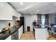Charming kitchen features white cabinets, granite countertops, and colorful curtains, with living area view at 4705 Hollingsworth Ave, Sarasota, FL 34233