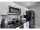 Modern kitchen with stainless steel appliances, white cabinets, and granite countertops at 4705 Hollingsworth Ave, Sarasota, FL 34233