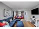 Cozy living room features a comfortable blue sectional couch, hardwood floors, and colorful decor at 4705 Hollingsworth Ave, Sarasota, FL 34233