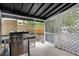 Covered patio with a grill, lattice privacy screen and view of the fenced backyard at 4705 Hollingsworth Ave, Sarasota, FL 34233