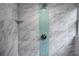 Shower featuring marble-like tile with a blue accent stripe and built in shelf at 4705 Hollingsworth Ave, Sarasota, FL 34233