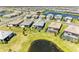 Wide aerial view of a single-story home with lush lawn, and screened lanai adjacent to a pond at 5129 Marina Basin Ct, Bradenton, FL 34211
