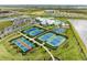 Aerial view showcases tennis courts, aquatic center, clubhouse, and a picturesque community setting at 5129 Marina Basin Ct, Bradenton, FL 34211