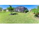 Expansive backyard with lush green grass, mature landscaping, and a screened lanai at 5129 Marina Basin Ct, Bradenton, FL 34211