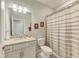 Bright bathroom featuring white cabinets, granite countertops, and a shower with a striped curtain at 5129 Marina Basin Ct, Bradenton, FL 34211