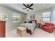 Cozy bedroom with carpet flooring, a ceiling fan and a large window for natural light at 5129 Marina Basin Ct, Bradenton, FL 34211