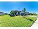 Beautiful single-story home featuring a manicured lawn, lush landscaping, and paved driveway at 5129 Marina Basin Ct, Bradenton, FL 34211