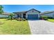 Charming one-story home with a paved driveway, two-car garage, and beautifully landscaped front yard at 5129 Marina Basin Ct, Bradenton, FL 34211