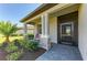Inviting front porch with stone accents, tiled floor, and a screened front door at 5129 Marina Basin Ct, Bradenton, FL 34211