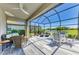 Screened-in lanai with comfortable seating area, ceiling fan, and views of the lake at 5129 Marina Basin Ct, Bradenton, FL 34211
