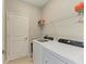 Efficient laundry room featuring modern washer and dryer, storage shelves, and a tiled floor at 5129 Marina Basin Ct, Bradenton, FL 34211