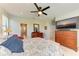 Comfortable main bedroom boasts en-suite bath, large TV, ceiling fan, and bright natural light at 5129 Marina Basin Ct, Bradenton, FL 34211