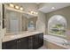 Bright bathroom features dual sinks, granite counters, a soaking tub, and a glass-enclosed shower at 5354 Nathaniel Pl, Sarasota, FL 34233