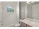 Bathroom with white-tiled shower and a vanity with a single sink under a mirror at 5354 Nathaniel Pl, Sarasota, FL 34233