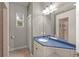 Bathroom with a double sink vanity featuring white cabinets and blue countertop at 5354 Nathaniel Pl, Sarasota, FL 34233
