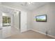 Carpeted bedroom with an open doorway and a television on the wall at 5354 Nathaniel Pl, Sarasota, FL 34233