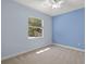 Bedroom with a ceiling fan, light blue walls, neutral carpet, and a window providing natural light at 5354 Nathaniel Pl, Sarasota, FL 34233