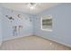 Bedroom with a fun space-themed design, carpeted floors, ceiling fan, and natural light from a window at 5354 Nathaniel Pl, Sarasota, FL 34233