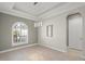 Bright dining room with tray ceiling, modern light fixture, and large arched window at 5354 Nathaniel Pl, Sarasota, FL 34233
