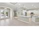 Open-concept kitchen featuring white cabinets, stainless steel appliances, pendant lights, and decorative ceilings at 5354 Nathaniel Pl, Sarasota, FL 34233