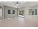 Open living room with tile flooring, a ceiling fan, large windows, and access to the backyard pool area at 5354 Nathaniel Pl, Sarasota, FL 34233
