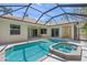 A sparkling pool and attached jacuzzi sit within a screened enclosure, surrounded by a tiled patio at 5354 Nathaniel Pl, Sarasota, FL 34233