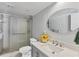 Bathroom featuring tiled shower and tub with a framed shower door, a vanity, and flowers at 540 Beach Rd # 510, Sarasota, FL 34242