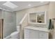 Bathroom featuring tiled shower and tub with a framed shower door, a skylight, and a white vanity at 540 Beach Rd # 510, Sarasota, FL 34242