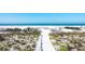Sandy path leading to a picturesque beach with clear blue water and soft white sand at 540 Beach Rd # 510, Sarasota, FL 34242