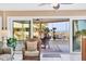 Living room with sliding glass doors opening onto a covered lanai with ocean view at 540 Beach Rd # 510, Sarasota, FL 34242