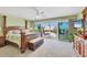 Spacious main bedroom with a four-poster bed and sliding doors to an outdoor patio at 540 Beach Rd # 510, Sarasota, FL 34242