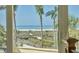 Close-up view of a serene beach scene through a window, showing sand, water, and palm trees at 540 Beach Rd # 510, Sarasota, FL 34242