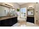 Bright bathroom featuring double vanities, a soaking tub, and neutral tile flooring at 541 Fore Dr, Bradenton, FL 34208