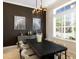 Elegant dining room with a large table, modern chandelier, and views through plantation shutters at 541 Fore Dr, Bradenton, FL 34208