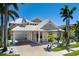 Beautiful home featuring a three-car garage, light gray exterior and tile roof with meticulous landscaping and lush palm trees at 541 Fore Dr, Bradenton, FL 34208