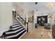 Spacious foyer showcasing black and white staircase, stylish lighting, and entryway leading to the dining and living spaces at 541 Fore Dr, Bradenton, FL 34208