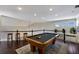 Spacious game room features a pool table, bar stools, and hardwood floors for entertaining at 541 Fore Dr, Bradenton, FL 34208