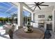Covered outdoor kitchen with grill, sink, bar, and seating area under a screened enclosure for relaxing and entertaining at 541 Fore Dr, Bradenton, FL 34208