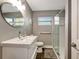 Bathroom featuring a large white sink, oval mirror and glass enclosed walk in shower at 5524 25Th W St, Bradenton, FL 34207