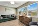 A cozy living room with a view from the window, black sofa, and a wooden dresser at 5524 25Th W St, Bradenton, FL 34207