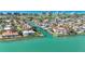 Aerial view of a luxury waterfront home with a pool and private boat dock on a canal at 560 Schooner Ln, Longboat Key, FL 34228