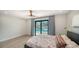Light and airy bedroom with ceiling fan, sliding glass doors to patio and pool area and light colored walls at 560 Schooner Ln, Longboat Key, FL 34228