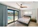 Bedroom with a ceiling fan and sliding glass doors that lead to a patio and pool area at 560 Schooner Ln, Longboat Key, FL 34228