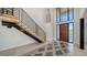 Elegant foyer with high ceilings, floating staircase, and modern tile flooring at 560 Schooner Ln, Longboat Key, FL 34228
