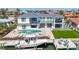 Aerial view of a modern home with a boat dock, outdoor pool, and well-maintained landscaping at 560 Schooner Ln, Longboat Key, FL 34228